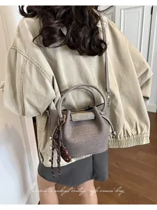 Detailed view of vintage grey crinkled women crossbody bag with top handle and charm.