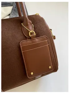 Braune Wildleder Boston Handtasche Detail zeigt Textur, passenden Kartenhalter Kette.