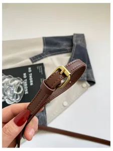 Nahaufnahme eines braunen Leder-Umhängetaschenriemens mit Metallschnalle, stilvolles Accessoire.