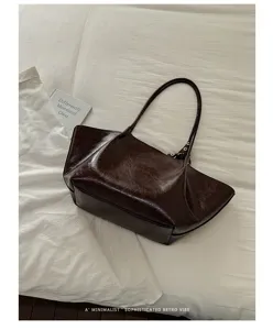 Nahaufnahme der braunen Vintage Ölwachs Leder Tote Tasche mit knittriger Textur und Details.