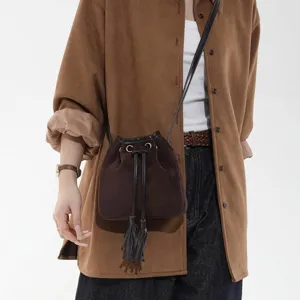 Retro brown suede bucket bag for women, stylish crossbody handbag with fringe and drawstring.