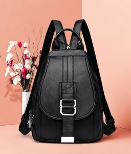 Detailed shot of black faux leather backpack featuring front flap closure and metallic hardware.