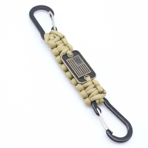 Close-up detail of the durable khaki paracord keychain with black metal carabiners and flag metal tag.