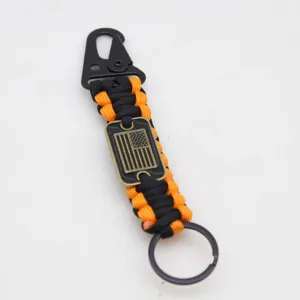 Detail view of black orange paracord tactical keychain with carabiner and flag tag.