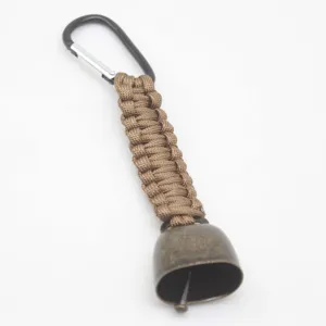 Outdoor camping bear bell detail, brown paracord lanyard with metal carabiner and bronze bell.