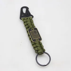 Close-up detail of the military green paracord survival keychain with US flag metal tag.