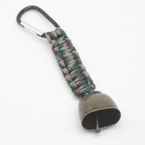 Close-up detail of the outdoor hiking camping bear bell paracord keychain and metal hook.