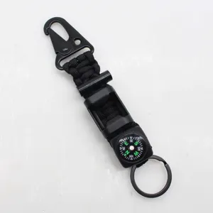 Detail view of tactical paracord survival keychain with compass, fire starter and carabiner.