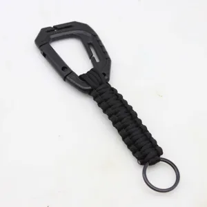Close-up detail of black paracord keychain with plastic carabiner and metal ring.