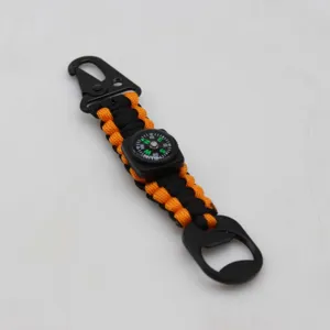 Primo piano del dettaglio del portachiavi in paracord nero e arancione con bussola.