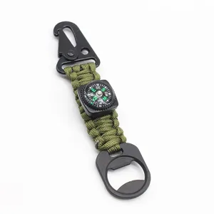 Primo piano dettagliato del portachiavi in paracord tattico con moschettone e bussola solida.
