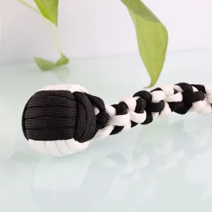 Black white paracord monkey fist keychain detail, steel ball self defense tool and braided lanyard.