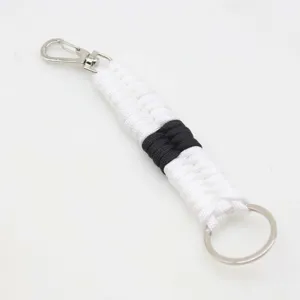Handmade paracord keychain detailed view, black and white woven rope with metal hardware.