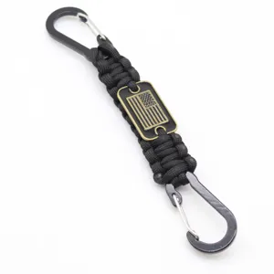 Black paracord keychain with dual carabiners and American flag metal tag for outdoor use.
