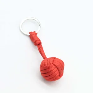 Red paracord monkey fist keychain for outdoor survival and daily tactical use item.