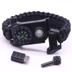 Detailopname van de zwarte paracord survivalarmband met ingebouwd kompas, led-licht en tondel.