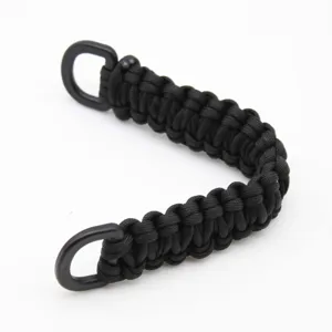 Black paracord handle detail, durable woven bag strap with metal D-rings, outdoor gear accessory.