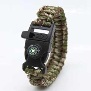 Detail shot of tactical survival paracord bracelet, featuring integrated compass and whistle buckle.