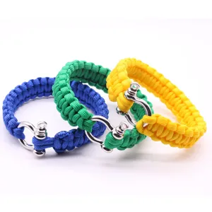 Gros plan détaillé de bracelets de survie en paracorde 7 brins avec manilles métalliques en couleurs.