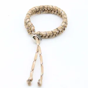 Closeup detail view of adjustable hand-woven paracord bracelet with metal bead and khaki cord.