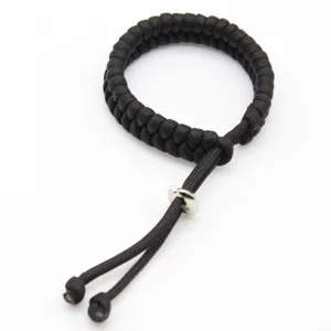 Detail view of black handmade paracord survival bracelet with adjustable metal slider clasp.