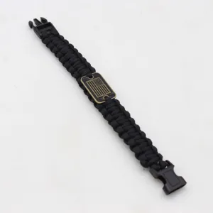 Black paracord survival bracelet with tactical buckle and American flag metal plaque detail.