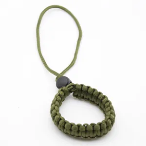 Close-up detail of green paracord camera wrist strap, tactical survival lanyard design.