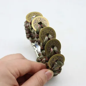Gros plan sur le bracelet en paracorde avec des pièces de monnaie des Cinq Empereurs.