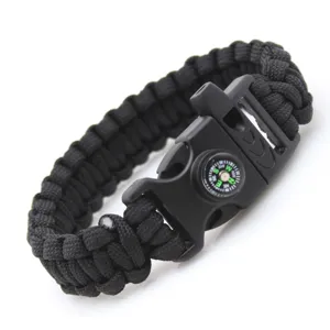 Black paracord survival bracelet detail shot featuring integrated compass and whistle.