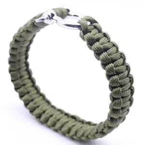 Gros plan détaillé sur le bracelet en paracorde vert avec un fermoir métallique robuste.