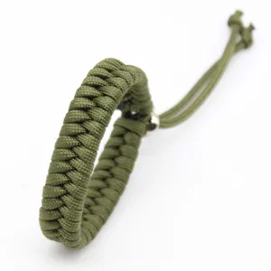 Close-up of the army green handmade paracord bracelet showing fine weaving and adjustable ends.