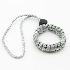 Paracord camera wrist strap detail, durable woven survival bracelet with black buckle.