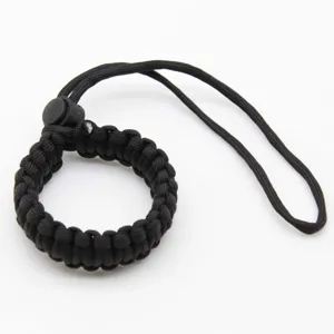 Black woven paracord camera wrist strap detail closeup, durable nylon survival lanyard cord.