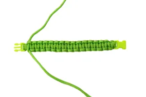 Green paracord bracelet close-up detail showing durable nylon weaving structure and plastic buckle.