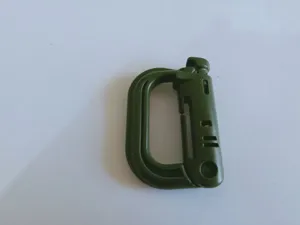 Green plastic carabiner detail view, durable D-ring clip for outdoor backpack gear and bags.