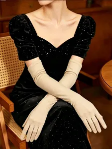 Detailed close-up view of long beige stretch spandex gloves paired with a black dress.
