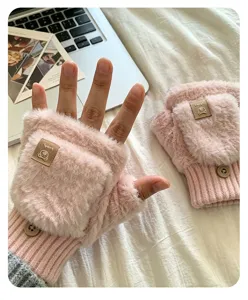 Primo piano di soffici guanti convertibili in peluche rosa con dettaglio di bottone.