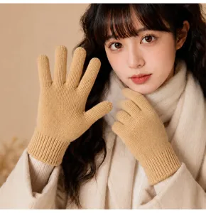 Close-up detail shot of solid color warm knit gloves worn by a model, cozy winter style.