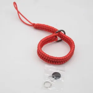 Vista di dettaglio del cinturino da polso per fotocamera in paracord rosso con anelli in metallo.