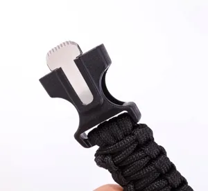 Closeup details of the black paracord survival bracelet buckle with a multi-functional metal tool.