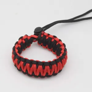 Close-up of handmade red black woven paracord camera strap detail and adjustable buckle.