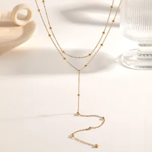 Detail shot of double layer gold Y necklace with small beads, elegant stainless steel jewelry.