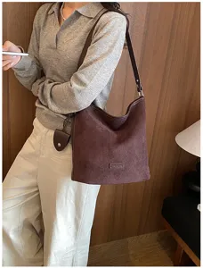 Chic dark brown suede shoulder bag for women, retro hobo bucket design with spacious capacity.