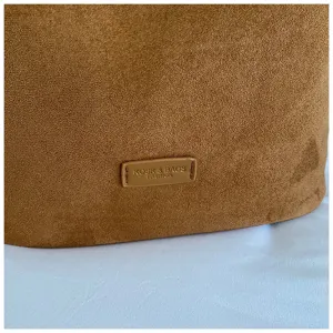 Brown suede bucket bag detail shot showcasing soft matte texture and embossed brand logo label.