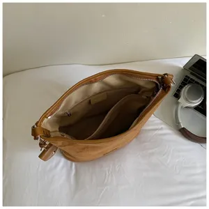 Detail view of brown suede shoulder bag interior, large capacity bucket bag lining.