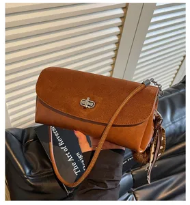 Chic brown suede shoulder bag with metal turn-lock and stylish scarf detail. Detail view.