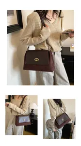 Chic brown suede shoulder bag detail view featuring elegant chain strap and metal lock clasp.