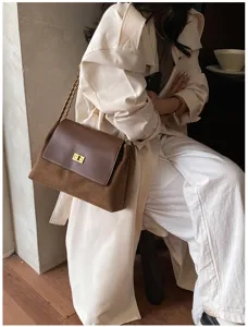 Stylish brown suede shoulder bag with metal chain strap and elegant turn-lock flap design.
