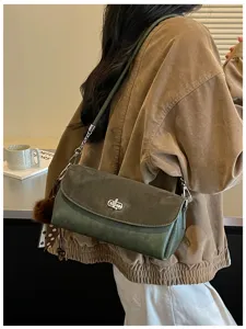 Green suede shoulder bag with metal turn-lock and chain strap. Stylish crossbody bag for women.