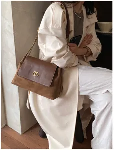 Chic brown leather shoulder bag with chain strap and elegant flap design for women.